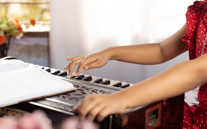 Kids playing harmonium and tabla at Tanpura Music School
